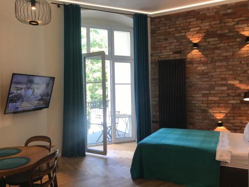 波兹南My Place in Poznan Centrum的一间卧室设有绿色的床和砖墙