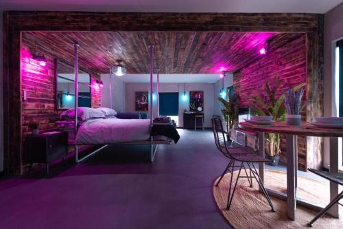 诺里奇31B Urban Stays的一间紫色照明的卧室,配有一张床和一张桌子