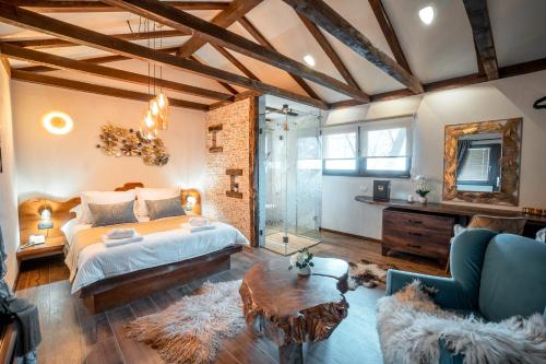 UzdojniceToplik Village Resort的一间大卧室,配有一张床和一个玻璃淋浴间