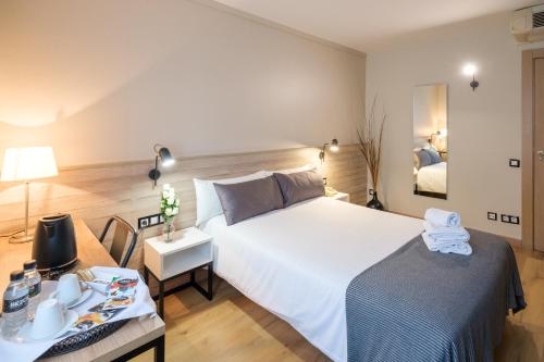 曼列乌Hotel Torres Manlleu的卧室配有一张白色的大床和一张桌子