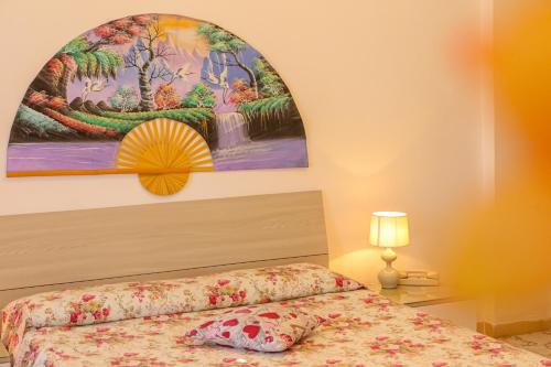 伊斯基亚Mini Hotel Rendez Vous的卧室配有一张床,墙上挂有绘画作品