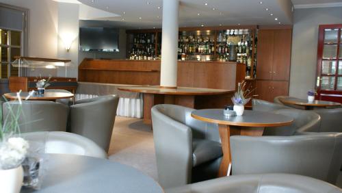 赫林贝亨修道院酒店 的一间带桌椅的餐厅和一间酒吧