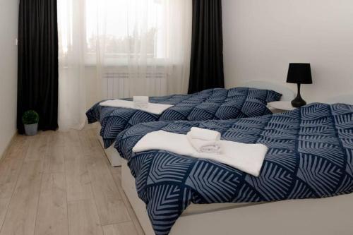 旧扎戈拉Super luxurious & spacious designer apartment.的卧室内的两张床,配有蓝色和白色的床单