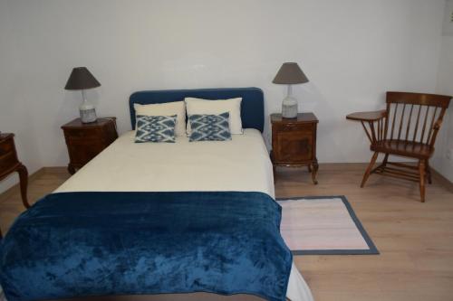 佩纳尔瓦堡Eiras do Dão的一间卧室配有一张大床,提供蓝色的床单和枕头