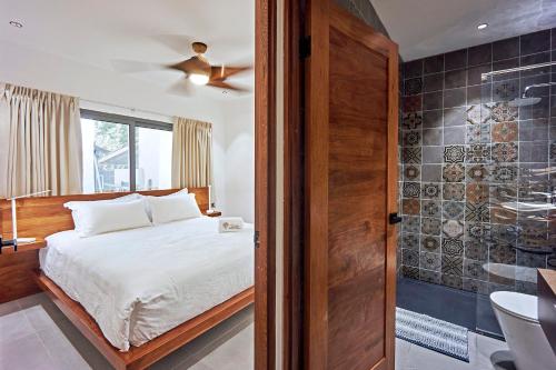 圣塔特蕾莎海滩NATURA Loft Garden的一间卧室配有一张床,浴室设有淋浴。