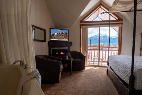 坎莫尔熊及野牛乡村酒店的一间卧室设有壁炉、一张床和一台电视。