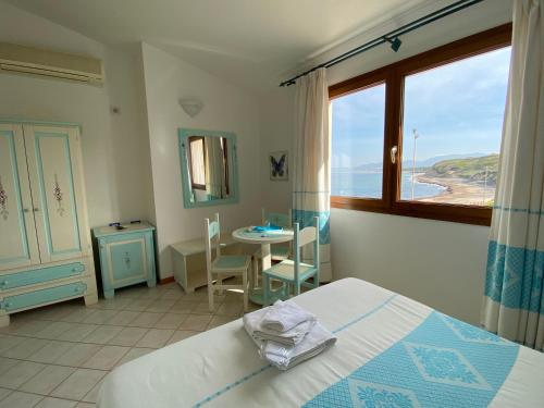 瓦雷多利亚La Locanda del Mare的一间卧室配有一张床、一张桌子和一个窗户。