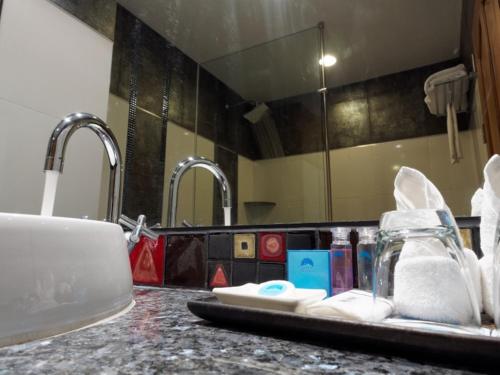 芭堤雅市中心芭堤雅蓝天酒店的浴室设有水槽以及带毛巾和牙刷的台面。