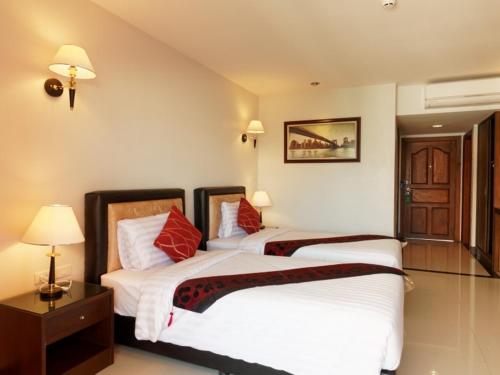 芭堤雅市中心芭堤雅蓝天酒店的配有2盏灯的酒店客房的2张床