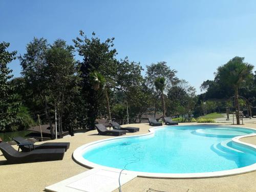 塞友Binlha Raft Resort的一个带躺椅和树木的大型游泳池