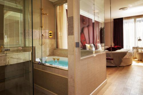 巴黎Paris j'Adore Hotel & Spa的带浴缸的浴室和卧室