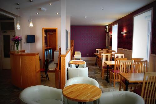 阿伯劳尔The Aberlour Hotel的一间带桌椅的餐厅和一间用餐室