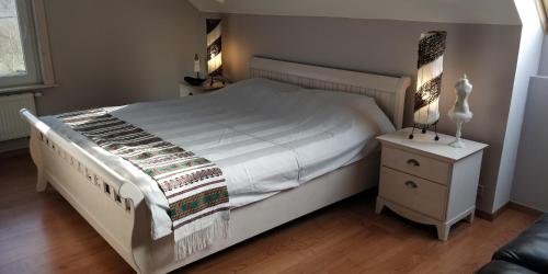 DurnalLe bordon的卧室配有白色的床和床头柜