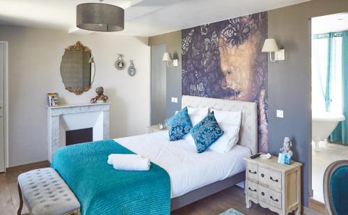 Sainte-Honorine-de-DucyDomaine de la Fauvriere的一间卧室配有一张带蓝色枕头的大床
