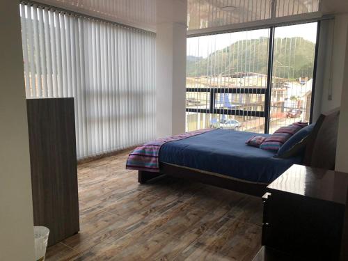 NobsaCasa Bertha Hotel y Servicios SAS的一间卧室设有一张床和一个大窗户