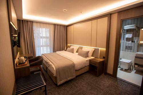 伊斯坦布尔BEST GARDEN HOTEL的酒店客房设有一张大床和一张书桌。