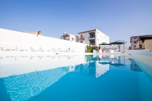 卡普多兰多Villa Concettina的一座拥有蓝色海水和白色建筑的游泳池