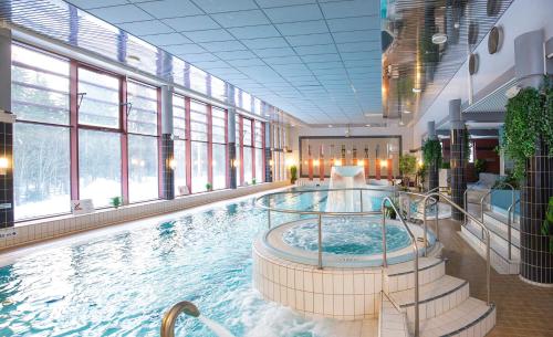 库奥皮奥劳哈拉赫蒂Spa酒店的一座大型游泳池,位于一座带窗户的建筑内