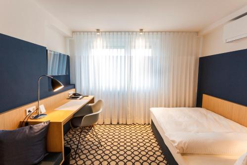 比蒂希海姆-比辛根奥特巴赫酒店的配有一张床和一张书桌的酒店客房