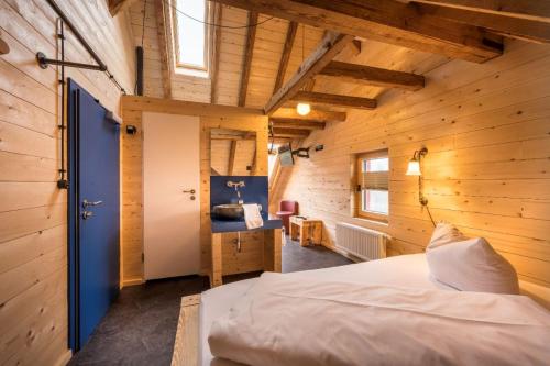 康斯坦茨Landgasthof Kreuz的一间带木墙的卧室和一张位于客房内的床