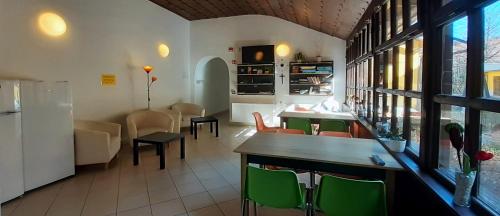 佩奇Ciszterci Szállás Pécs的一间设有绿色椅子的餐厅和一间用餐室
