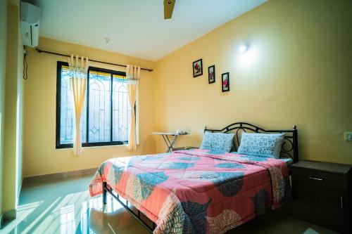 瓦尔恰Field stone Apartment的一间卧室配有一张带彩色毯子和窗户的床。