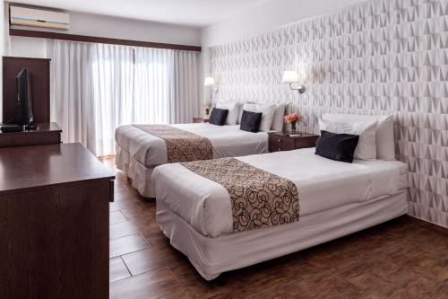 布宜诺斯艾利斯Ker Belgrano Hotel的酒店客房设有两张床和电视。