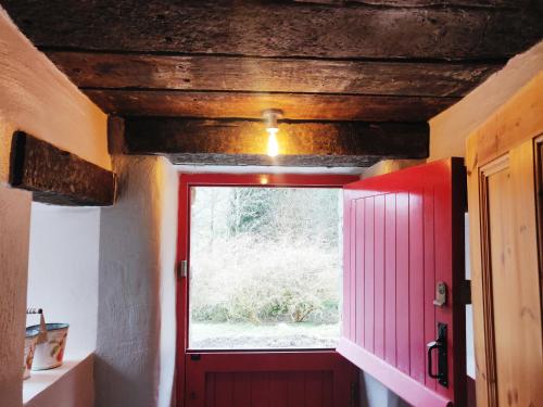 ManorhamiltonGlenkeel Cottage的一间设有红色门和窗户的房间