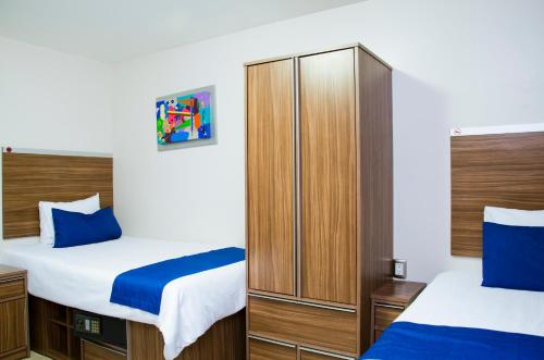 墨西哥城La Casa Azul (Zona de Hospitales)的一间卧室配有两张床和衣柜