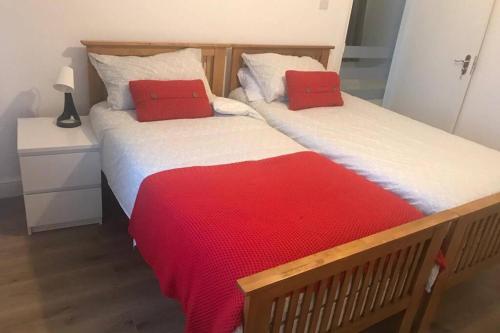 KentThe Dartford Five Bedrooms Attractive House的两张带红色枕头的床,彼此相邻