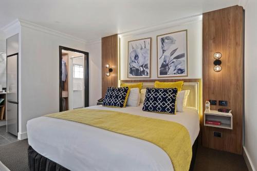 达博Bluegum Dubbo Motel的一间卧室配有一张大床,提供黄色和蓝色的枕头