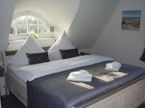 奥斯特巴德里克Fairy tale holiday home in Rerik with private terrace的一间卧室配有一张带两条白色毛巾的床