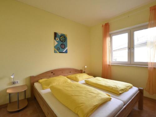 齐罗Relaxed Apartment in Puerto del Carmen with Swimming Pool的一间卧室设有两张带黄床单的床和窗户。
