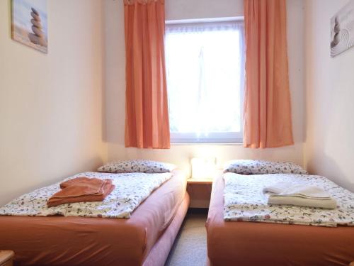 奥斯特巴德里克Cozy apartment in Rerik Germany near Sea的带窗户的客房内的两张床