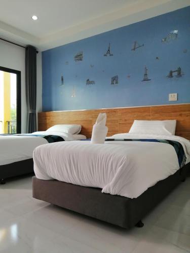 Sangkhomเคียงภูวิลล่า的卧室设有两张床铺,拥有蓝色的墙壁