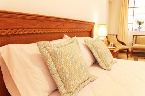 基多加斯广场酒店的一间卧室配有一张带两个枕头的床
