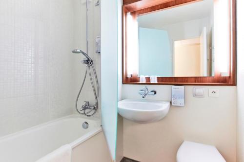 布西圣乔治布西圣乔治马恩河谷钟楼酒店的一间带水槽、卫生间和镜子的浴室