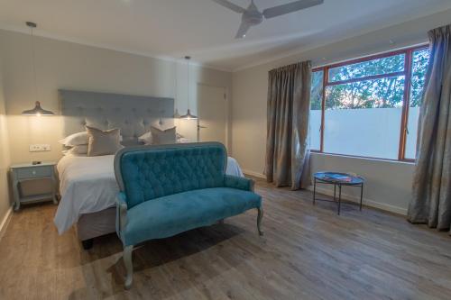 赫曼努斯Penguino Guesthouse的一间卧室配有一张床和一张蓝色椅子
