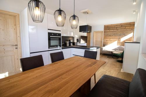 穆劳附近圣洛伦岑Kreischberg Suites by ALPS RESORTS的厨房以及带木桌和椅子的用餐室。
