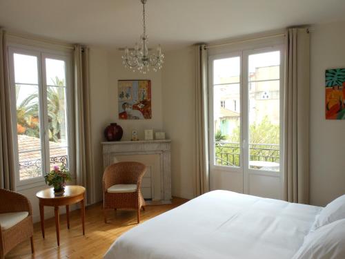 尼斯辛格涅斯别墅酒店的卧室配有一张床和一张桌子及椅子