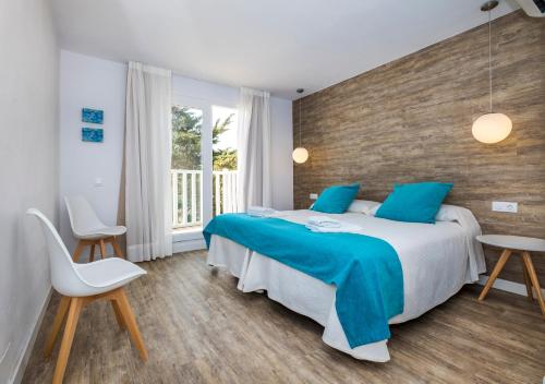马翁Apartamentos Playa Canutells的一间卧室配有一张带蓝色枕头的大床