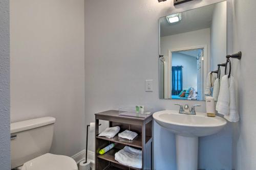 海泉市Downtown Ocean Springs Retreat 1 Mi to Beach!的一间带水槽、镜子和卫生间的浴室