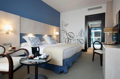 马德里纽沃波斯顿酒店的酒店客房带一张床、一张桌子和椅子