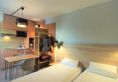 托尔西托尔西公寓式酒店的配有床和桌子的房间以及厨房