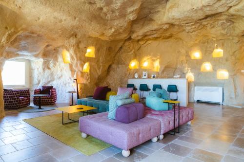 马泰拉La Corte Dei Pastori Luxury的带沙发和岩石墙的客厅