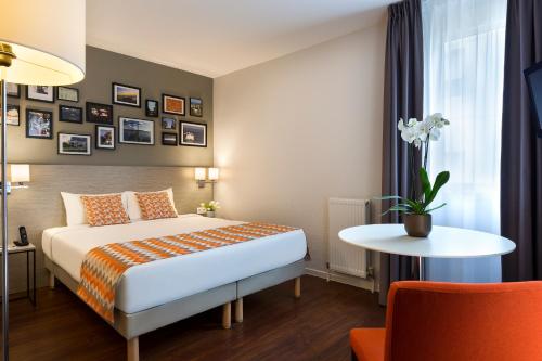 蒙彼利埃馨乐庭佩里尔峰昂迪格纳酒店的酒店客房配有一张床铺和一张桌子。