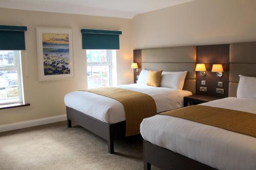 康多纳Joyce's Carndonagh Inishowen的酒店客房带两张床和两个窗户