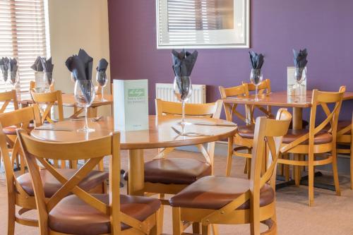 贝尔福德普尔蒂旅馆的用餐室配有木桌和椅子