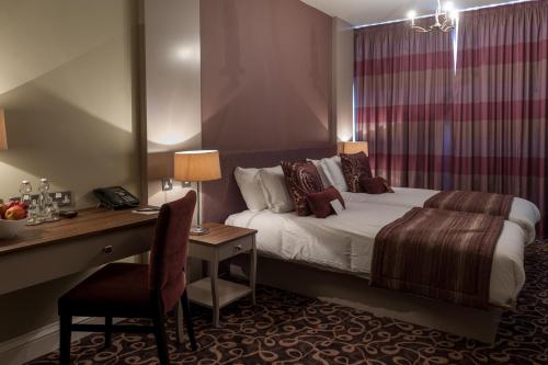 谢菲尔德哈利法克斯市政厅酒店的酒店客房配有一张床和一张带椅子的书桌