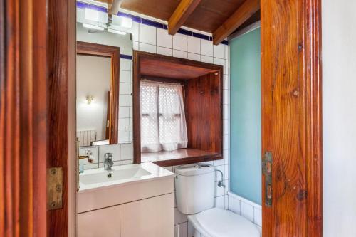 塔科龙特Finca Los Viñedos Casa Rural的一间带卫生间、水槽和镜子的浴室